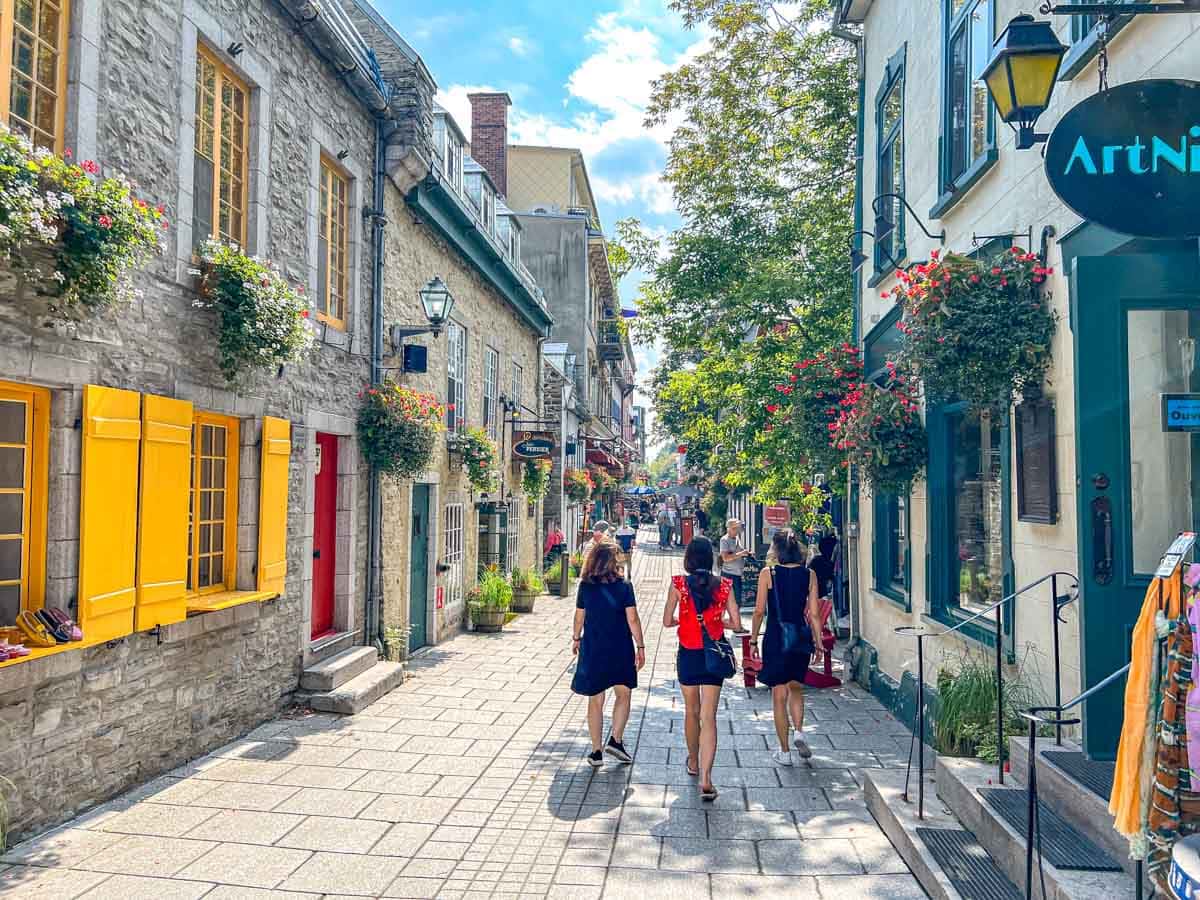 colourful old town street with people walking down it in quebec city.